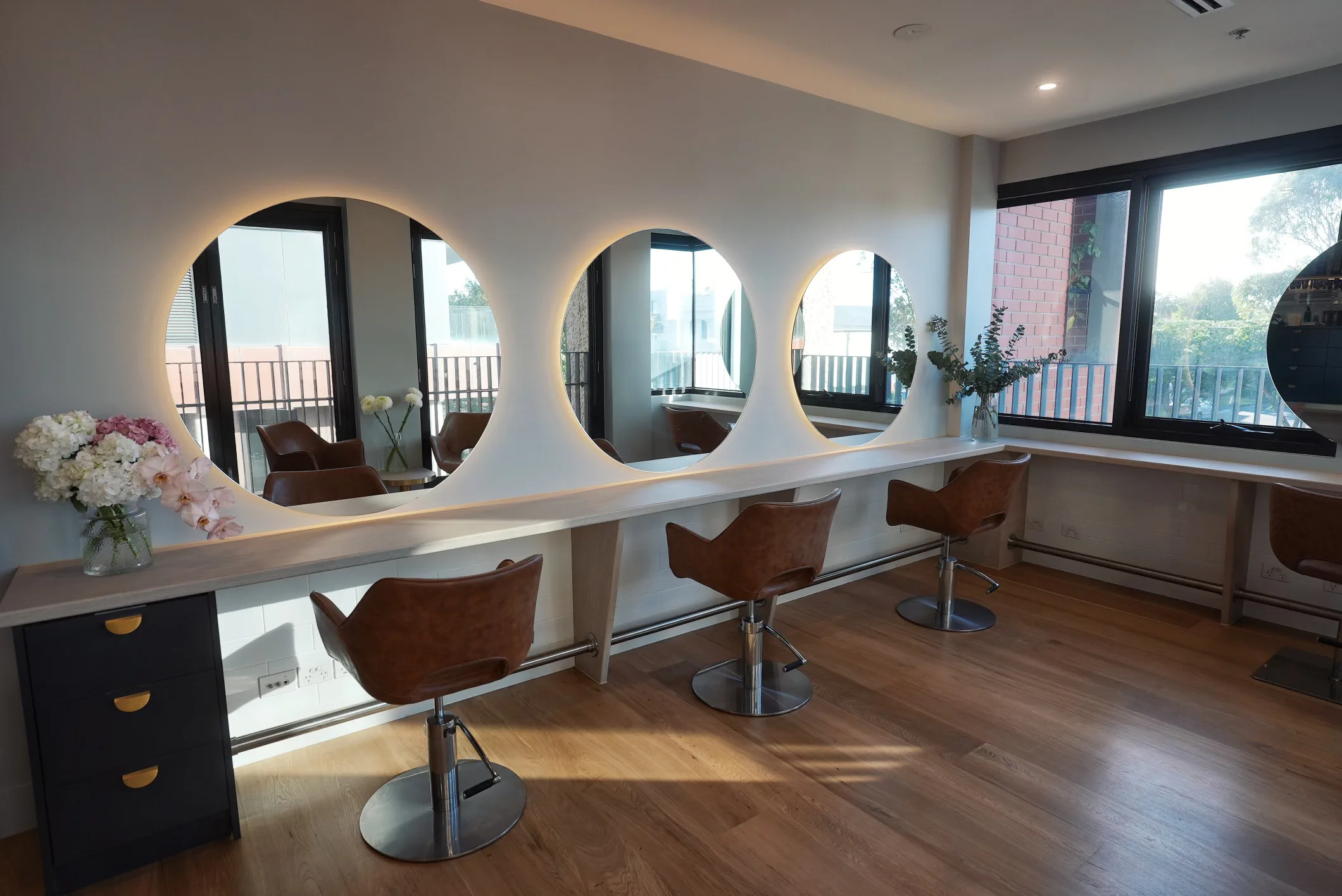 Richmond interior — row of arched mirrors and tan chairs at styling stations
