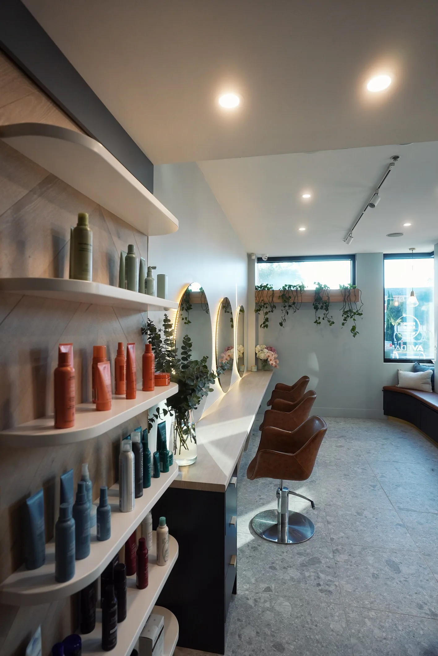 Richmond salon — colourful product bottle shelf wall and styling area